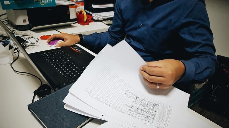 midsection-businessman-working-laptop-with-documents-desk-office_1048944-12829556