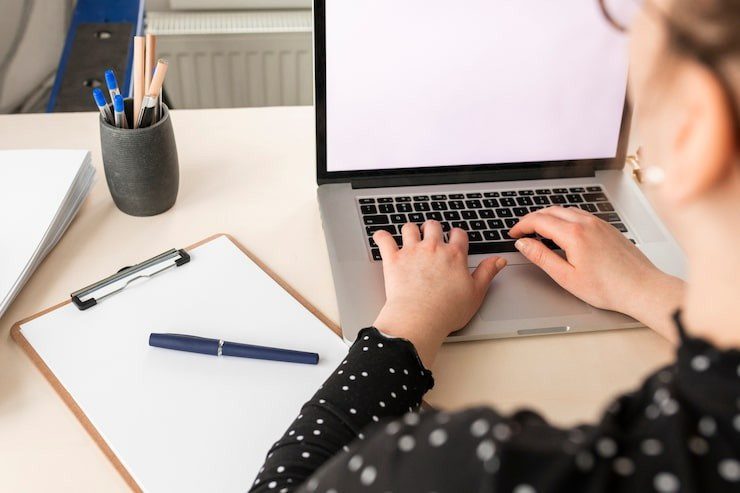 high-angle-woman-working-empty-display-laptop_23-2148488633